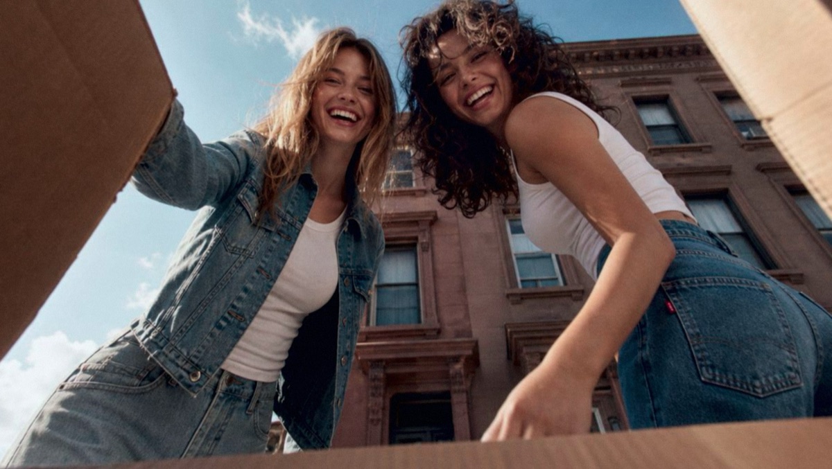Two models in Levi's denim looking down into a moving box
