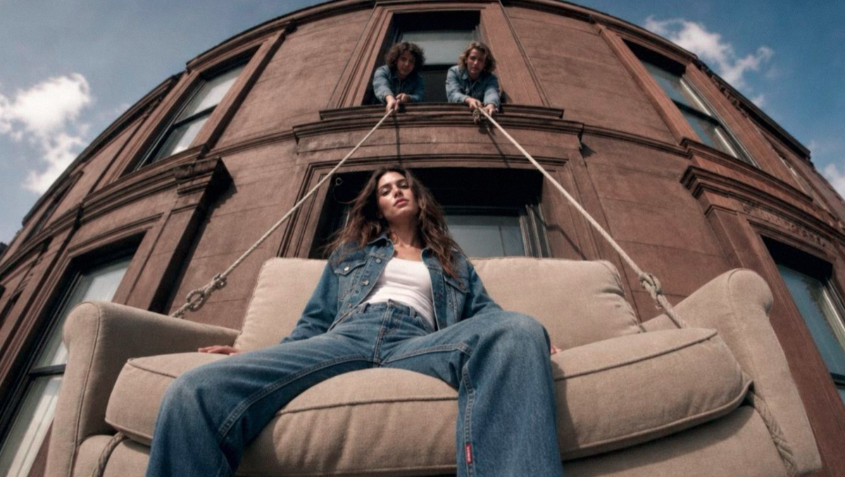 Model riding a sofa hauled up a brownstone