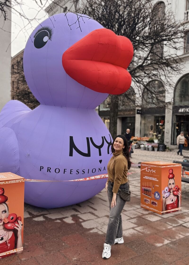 The real NYX inflatable: a giant lavender duck with red lips on a shopping street