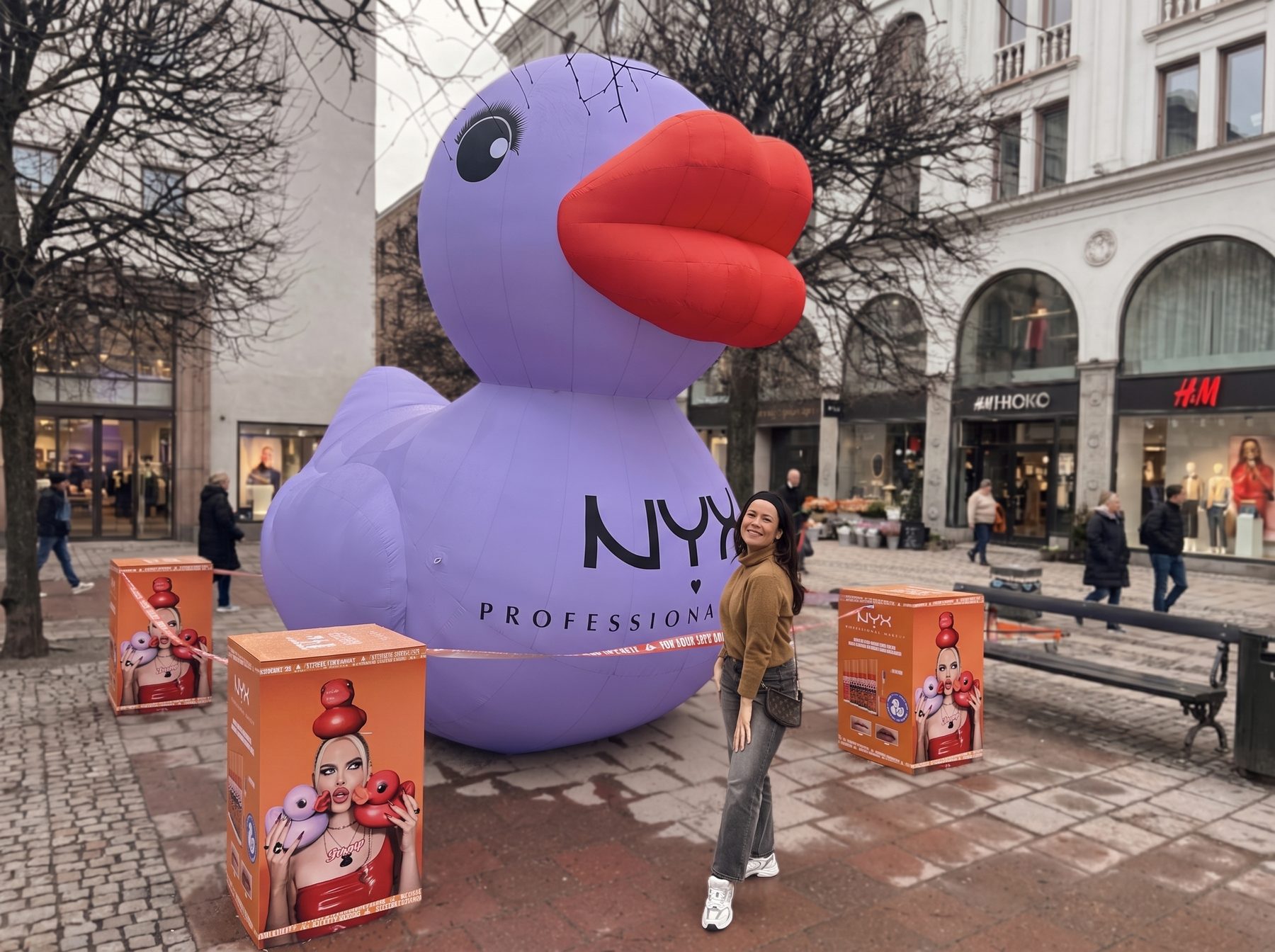 The giant NYX duck inflatable with glossy red lips we built for the Duck Plump launch, on a shopping street